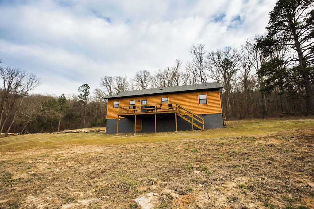 Ein eingeschossiges Holzhaus mit einer Veranda und einer Treppe zum Eingang.