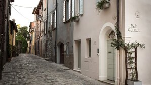 Una estrecha calle empedrada flanqueada por edificios históricos, algunos con balcones y ventanas a la vista.