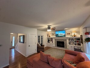 A living room with a fireplace, a television, and a ceiling fan. - FIFA World Cup Hub: 8 Mins to Arrowhead + Pool! (Independence)