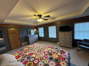 A bedroom with a large bed, a ceiling fan, a dresser, a television, and a window with blinds. - FIFA World Cup Hub: 8 Mins to Arrowhead + Pool! (Independence)