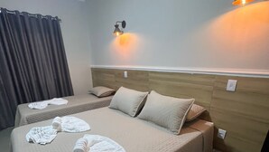 A hotel room with two beds, a wooden headboard, wall-mounted lights, and a curtain. - Pousada Vila Palmital (Paraty)