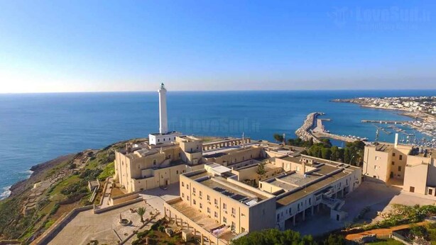 Complejo de edificios costeros con un faro destacado, que incluye varios edificios y vistas al mar.