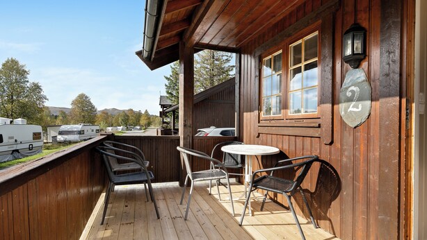 A wooden deck with outdoor seating and a stone number plaque. - First Camp Beitostølen - Valdres (Beitostølen)