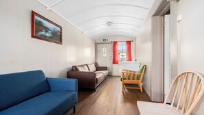 A hallway with a blue sofa, a brown sofa, a wooden chair, and a wooden bench. - First Camp Beitostølen - Valdres (Beitostølen)