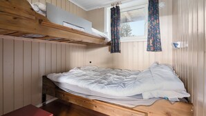 A bunk bed with a wooden headboard, a window with curtains, and a small table. - First Camp Beitostølen - Valdres (Beitostølen)