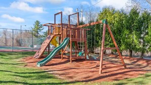 A playground with a slide and climbing structures. - Weirs beach retreat (Laconia)