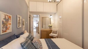 A bedroom with a bed, a dresser, a chair, and artwork on the wall. - S P ART Boutique Acropolis (Athina)