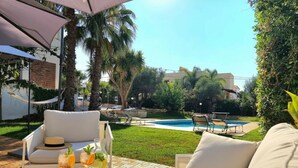 A patio with a pool, outdoor furniture, and a magazine on a table. - VFH The Sicilian Dream Pool Villa (Altavilla Milicia)