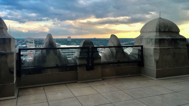 Eine Dachterrasse mit Blick auf die Stadtlandschaft, gekennzeichnet durch modernes Architekturdesign mit Metallgeländer und Fliesenböden.