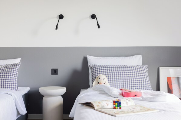 A bedroom with a bed, pillows, a bedside table, a lamp, and a Rubik's cube. - Solo Society Hybrid Hotel Vilnius (Vilnius)