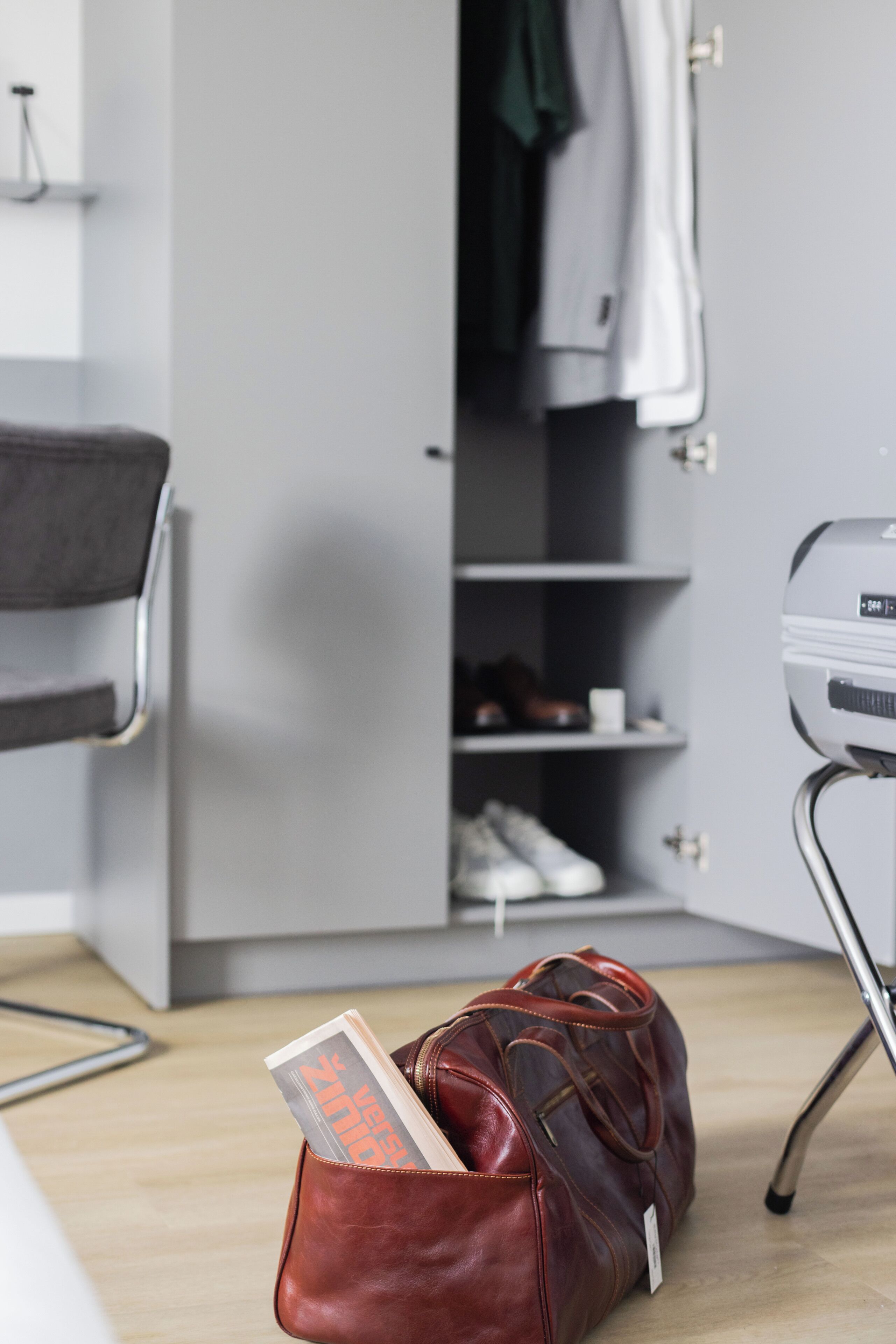 A room with a bed, a desk, a chair, a wardrobe, and a shoe rack.