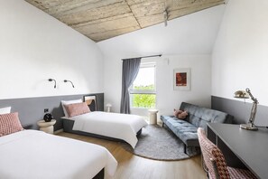 A modern hotel room with two beds, a sofa, a desk, and a large window with curtains. - Solo Society Hybrid Hotel Vilnius (Vilnius)
