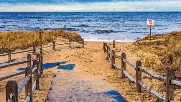 A wooden boardwalk leading to a beach with a sign reading "KEEP OFF THE DUNES". - Game Room, Cozy & Mins to Beaches! (Eastham)