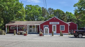 A red building with a sign reading "The Landing" and a truck parked in front. - Game Room, Cozy & Mins to Beaches! (Eastham)