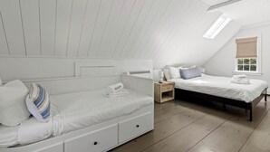 A bedroom with two beds, a window with a view, and a skylight. - Walk to Water, Cozy, Dog Friendly! (Orleans)
