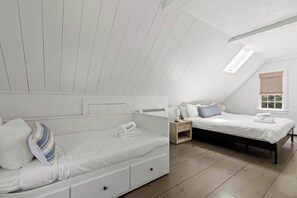 A bedroom with two beds, a window with a view, and a skylight. - Walk to Water, Cozy, Dog Friendly! (Orleans)