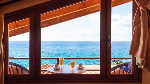 A wooden-framed window with a view of the ocean. - Villa Maria Apt 2 (Ligres)