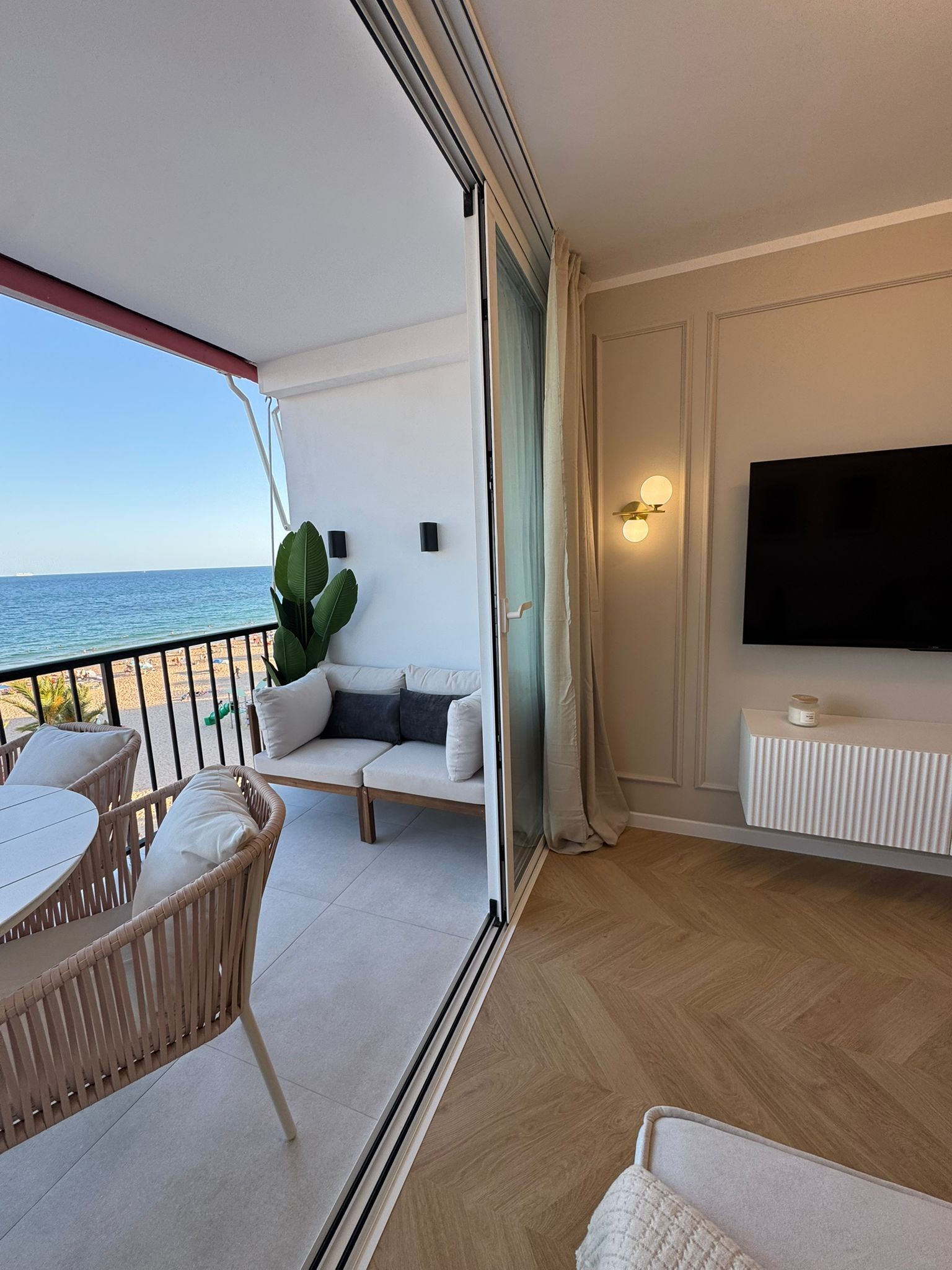 Un balcón con sofá, sillas y una mesa con vista al mar.