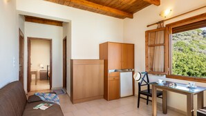 Una cocina compacta con armarios de madera, un refrigerador y una mesa de comedor con sillas.