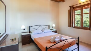 Un dormitorio con cama, mesitas de noche, un espejo y una ventana con cortinas.