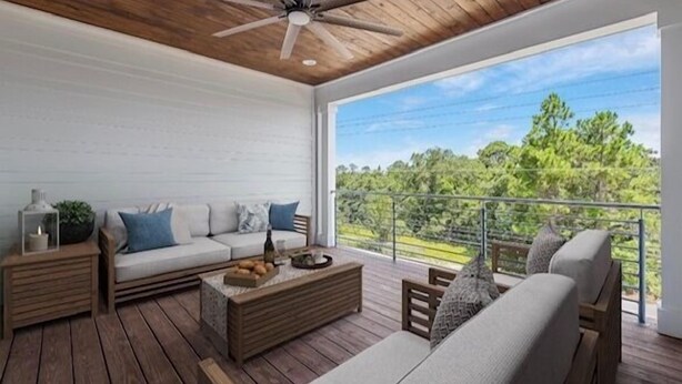 Uma varanda espaçosa com deck de madeira, um sofá, uma mesa de centro e um ventilador de teto.