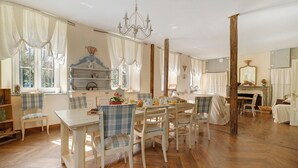 Un espace repas doté d’un parquet en bois disposé en motif chevron, de meubles blancs et d’un lustre.