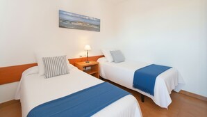 Ein Hotelzimmer mit zwei Betten, einem Nachttisch mit Lampe und einem Bild an der Wand.