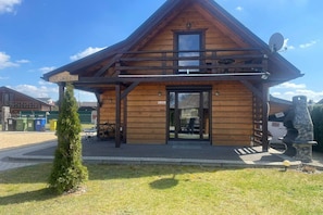 Un bâtiment en bois, avec une enseigne portant l’inscription « JEDREK », une petite entrée et une antenne parabolique.