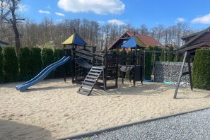 A playground with a slide and climbing structures.