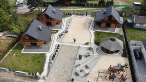 A lodge with multiple cabins, a central courtyard, and a playground area.