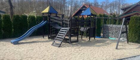 Ein Spielplatz mit Rutsche und Klettergerüsten.