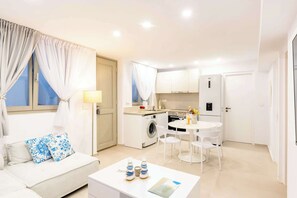 A modern apartment with a living room, a dining area, a kitchen, and a laundry area. - Eidolion Essence - Cozy Guest House Mykonos (Ano Mera)
