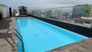 A rooftop pool with a clear view of the city skyline. - APT GRAÑA - MAGDALENA  (Lima)
