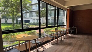 A modern interior with large windows, wooden flooring, and metal chairs. - APT GRAÑA - MAGDALENA  (Lima)