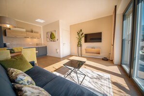 A modern living room with a sofa, a coffee table, and a TV mounted on the wall. - Chalet Agave I Luxury Adults Only | Olive 742B (Caldaro sulla strada del vino)