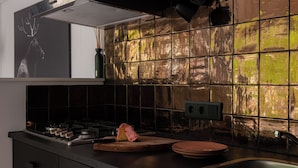 Una cocina moderna con estufa a gas, tabla de cortar de madera y un lavamanos.