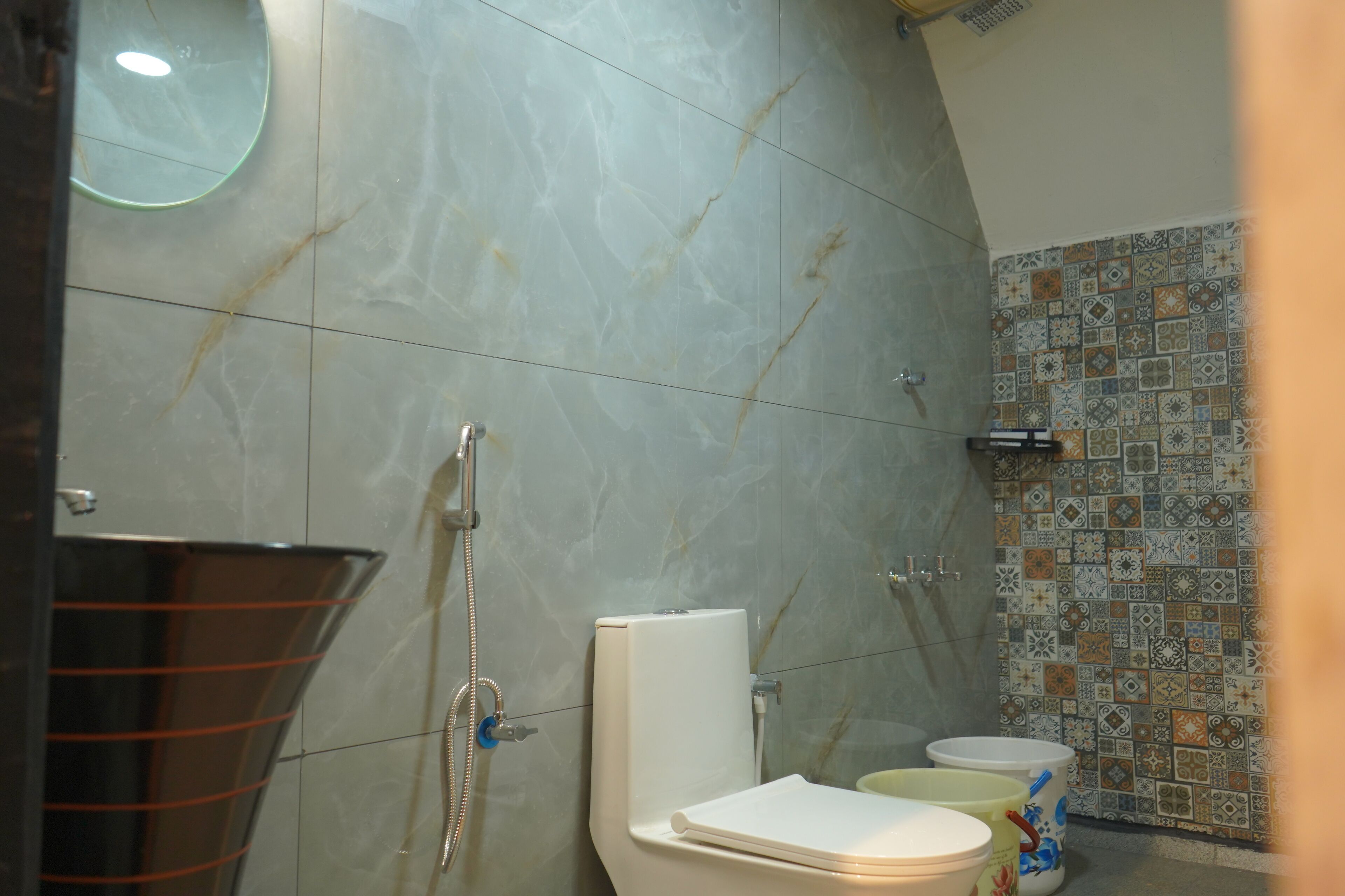 A bathroom with a toilet, bidet, and shower.