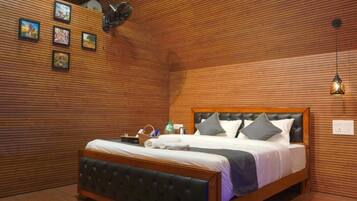 A neatly made bed with a wooden headboard, a wall-mounted shelf with various items, and a hanging light fixture.