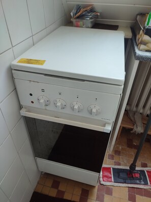 A kitchen with a white stove, a tiled backsplash, and a tiled floor. - HELLO AND WELCOME. (Rostock)