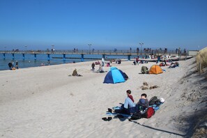 A beach with tents and people relaxing.