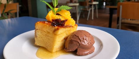 Un plato de postre con una porción de pastel y una bola de helado sobre un plato blanco.