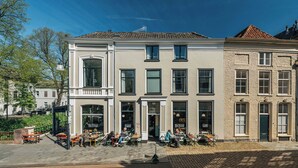 Un edificio con una cafetería en la planta baja, múltiples ventanas y una puerta con la etiqueta 'RES'.