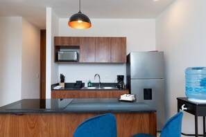 A modern kitchen with a central island, stainless steel appliances, and a water dispenser.