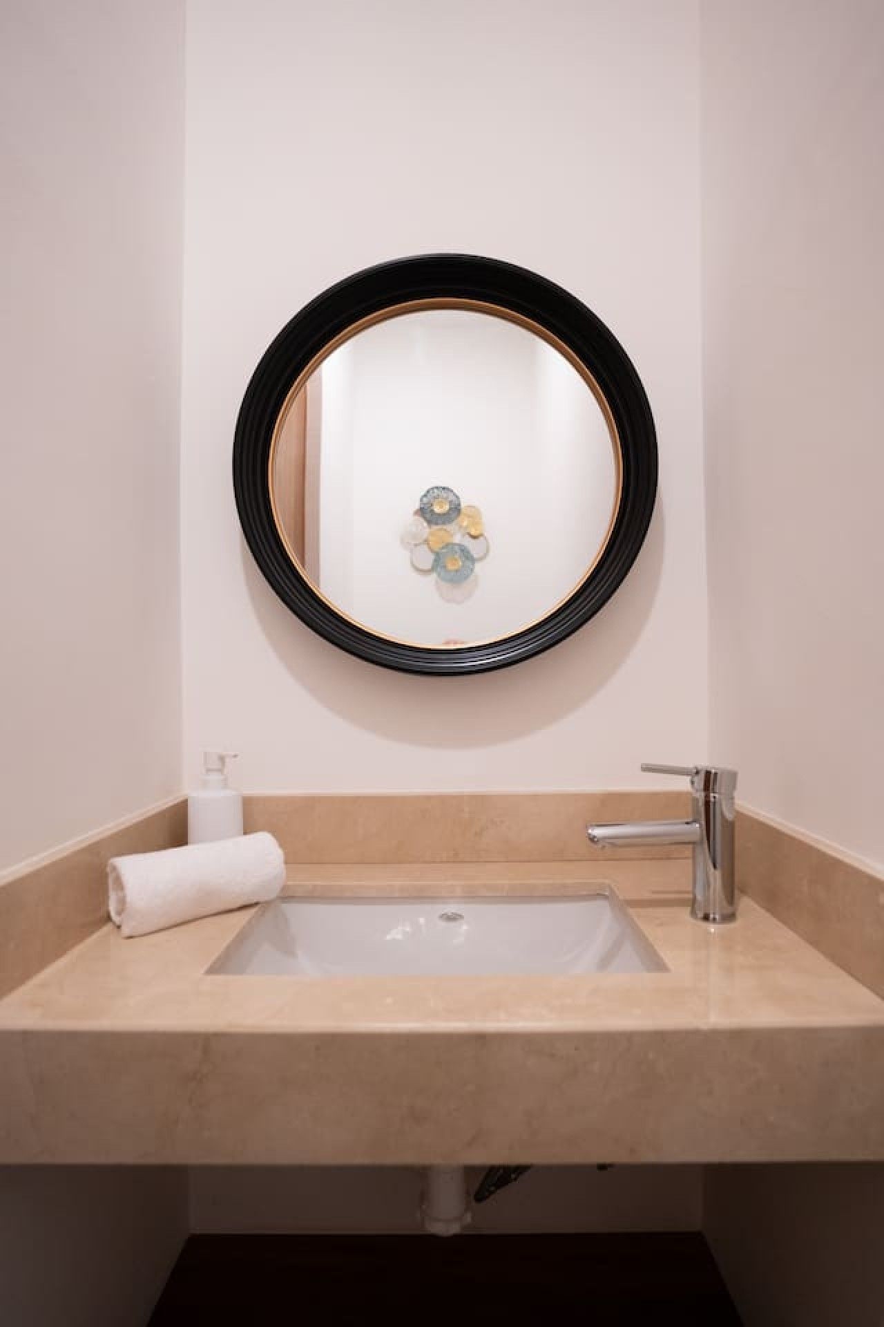 Un baño con lavamanos, espejo y toalla.