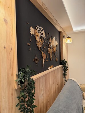 Una parete con una mappa, una bussola, pannelli in legno e una pianta.