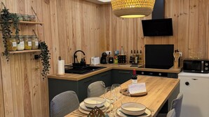 Una cucina moderna con rivestimenti in legno, un'isola centrale e una lampada a sospensione.