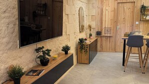 Un interno moderno con televisione integrata, elementi in legno e zona pranzo.