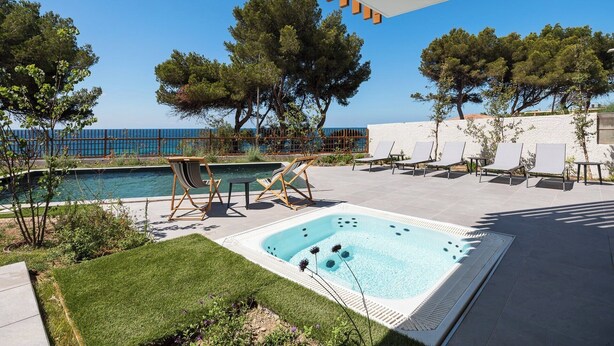 A pool area with lounge chairs, a hot tub, and a view of the sea. - La Corniche Bleue (Sausset-les-Pins)