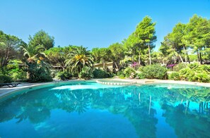 A clear swimming pool surrounded by lush greenery and trees. - Residence with swimming pool in Santa Margherita di Pula (Santa Margherita di Pula)