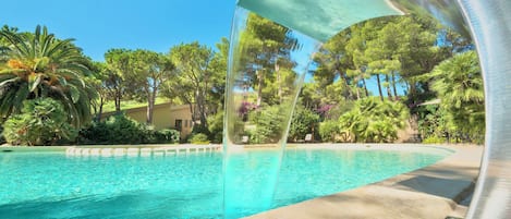 Una piscina al aire libre de temporada, sombrillas, tumbonas